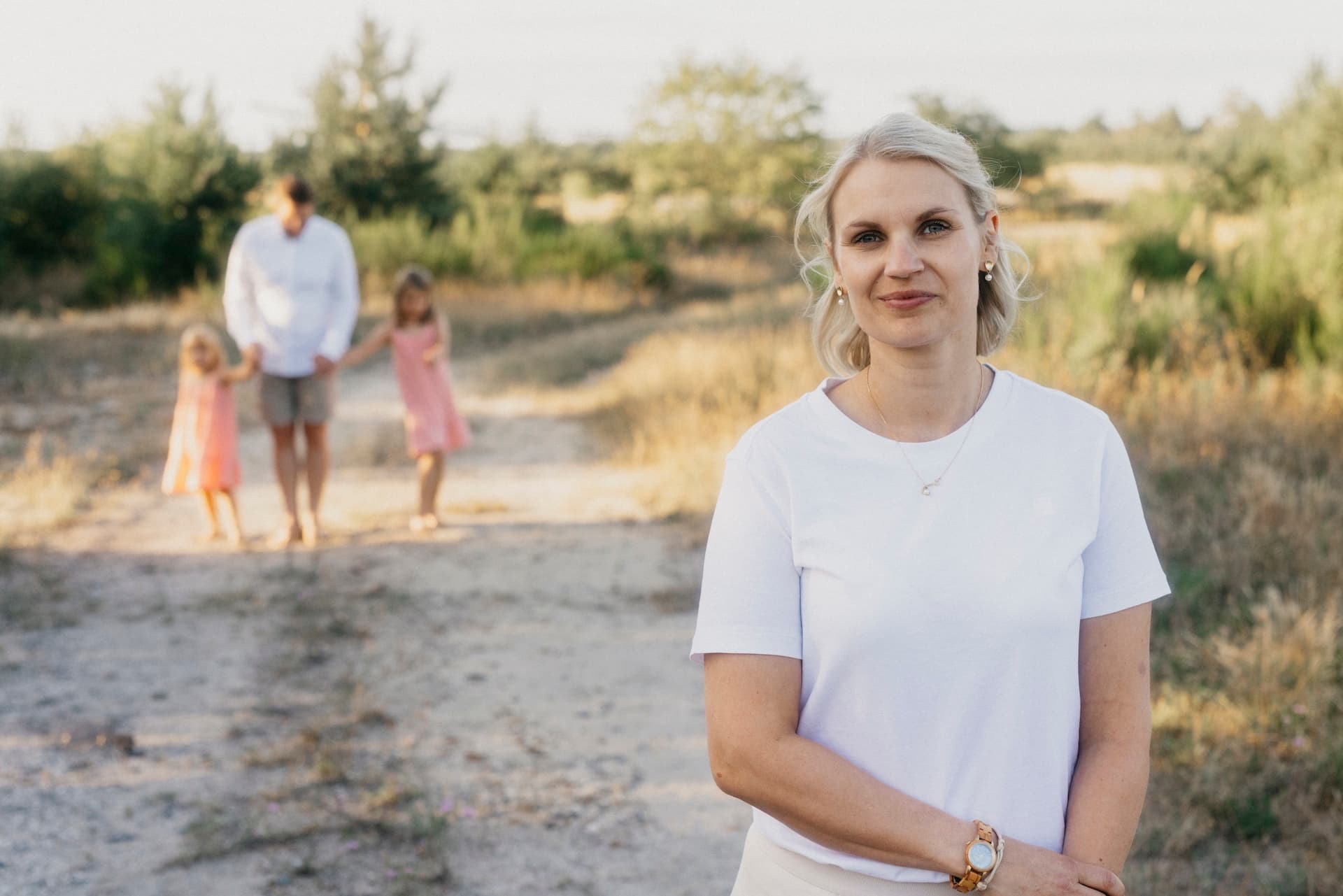 Susann Hoppe auf einem Feldweg mit einer Familie im Hintergrund